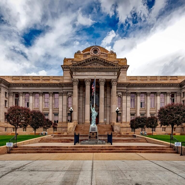 Front view of a neoclassical courthouse building in Colorado with lush greenery.