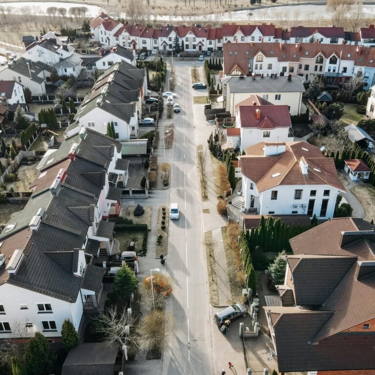 Aerial view of a suburban neighborhood with houses, streets, and cars.