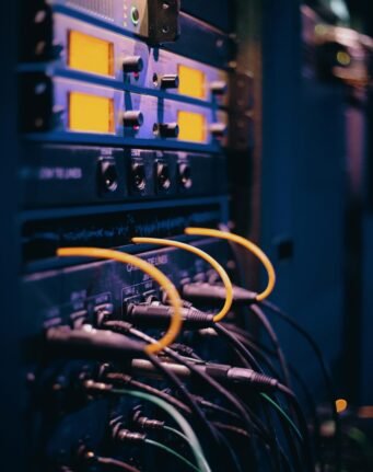Close-up of network cables and ports in a server rack, showcasing connectivity.