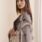 Stylish woman in embroidered dress showcasing elegance and beauty.