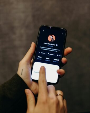Hands holding a smartphone displaying a social media profile interface. Technology and modern connections.