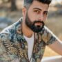 pexels-photo-8350413-8350413 Close-up portrait of a stylish, bearded man outdoors in natural sunlight.